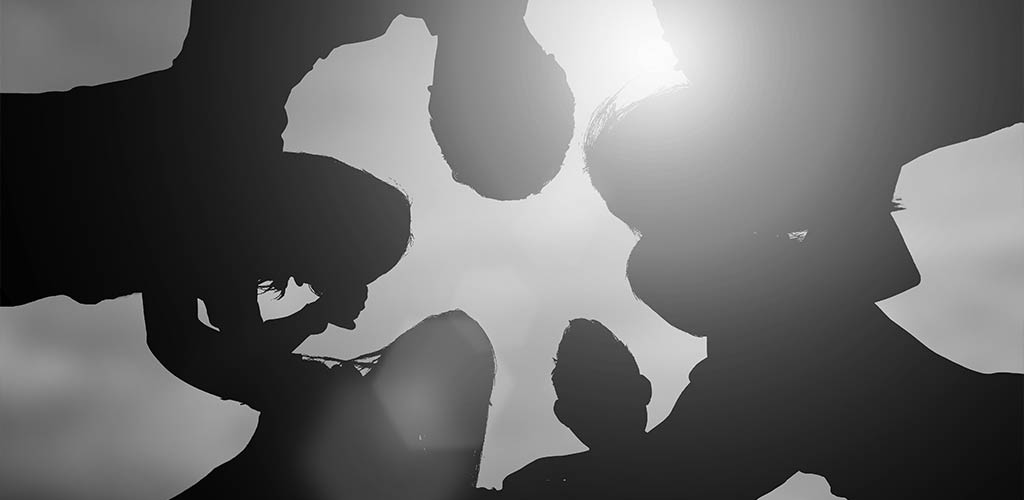 Silhouette of people embracing showing collaboration and leadership